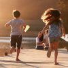 Children Run Towards Parents On Wooden Jetty By Lake